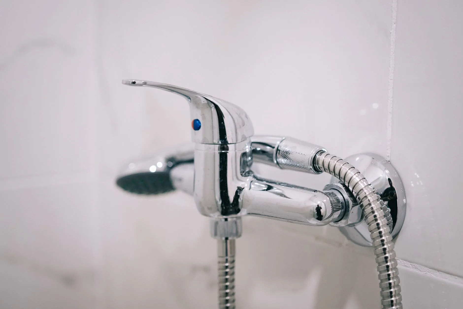 Main testant l'eau froide sous un robinet de douche, situation ouvrant droit à un dédommagement pour absence d'eau chaude